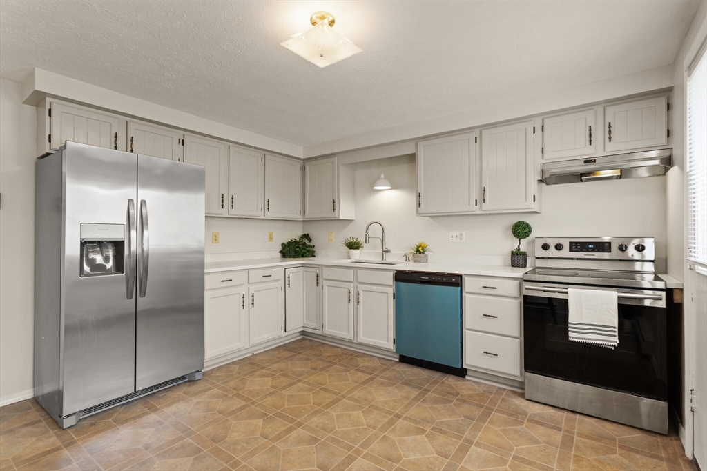 a kitchen with cabinets stainless steel appliances and a counter top