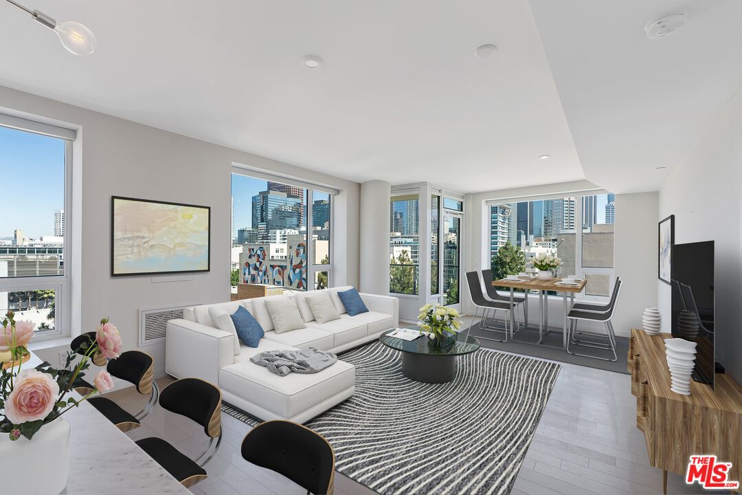 a living room with furniture a large window and a flat screen tv