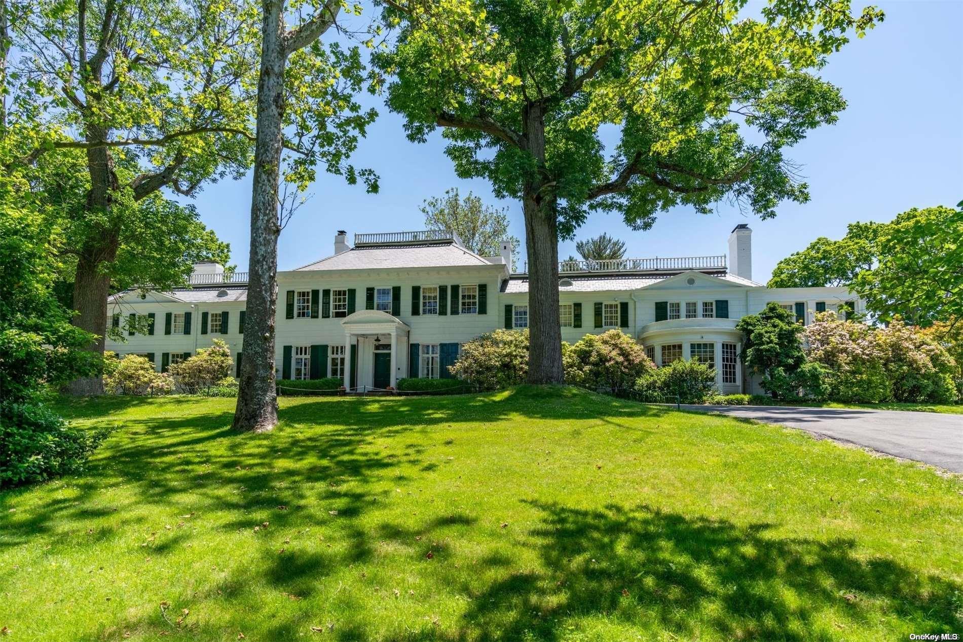 a view of a house with a yard and large trees