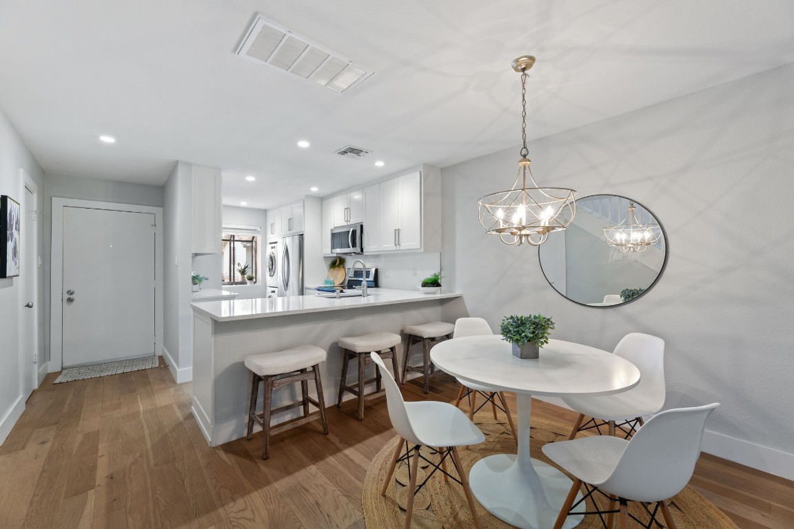 a view of a dining room with furniture a chandelier and wooden floor