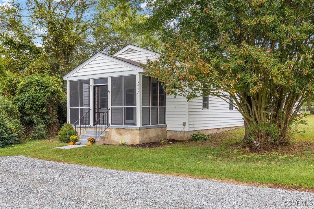 a front view of a house with a yard and garden