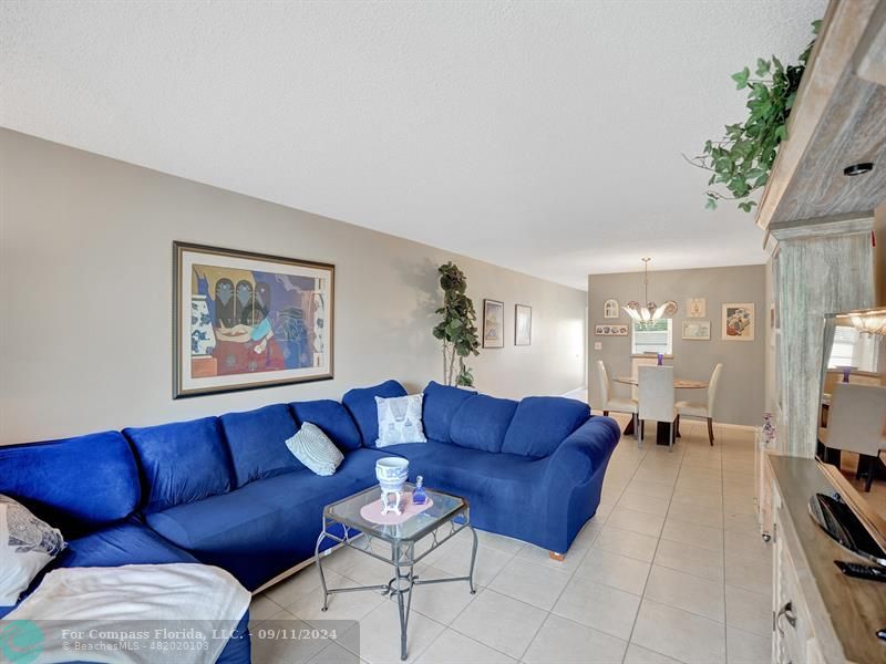 a living room with furniture a couch and a potted plant