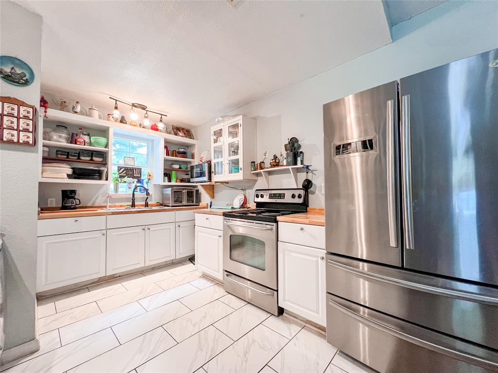 a kitchen with stainless steel appliances granite countertop a refrigerator sink and stove