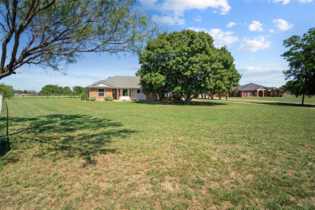 a view of a big yard with a house in the background