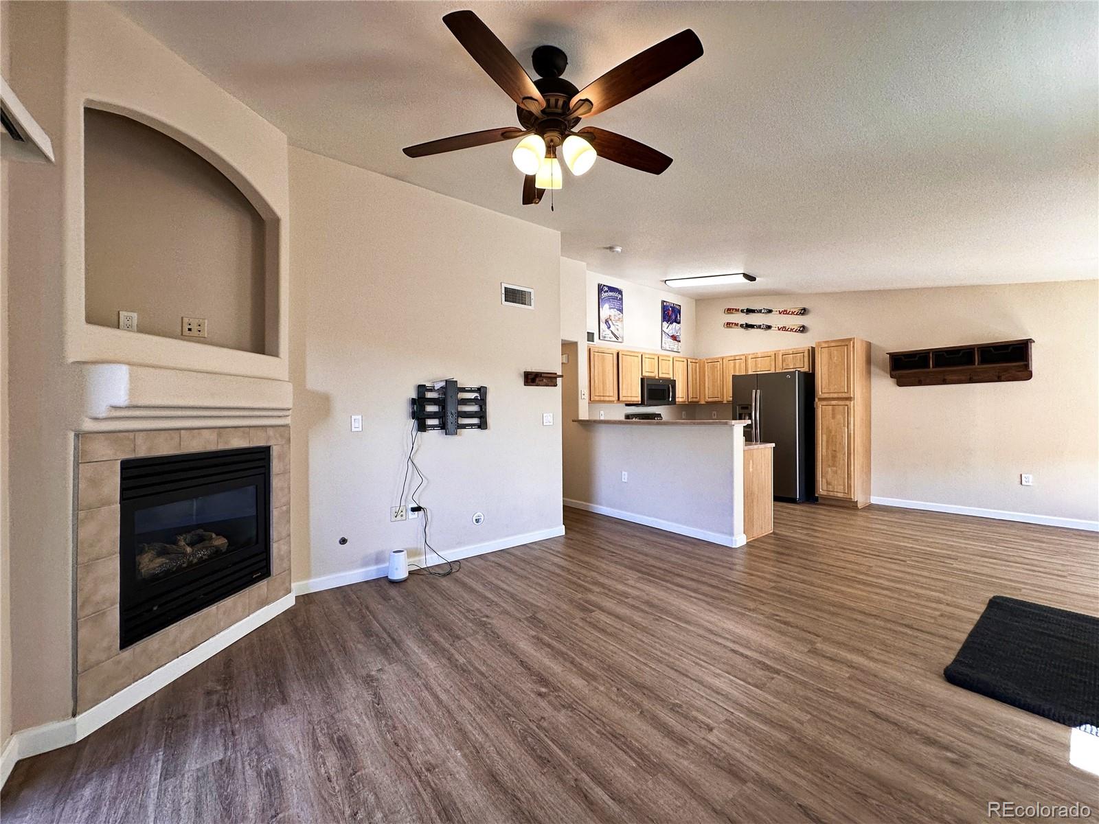 a view of empty room with wooden floor and fireplace