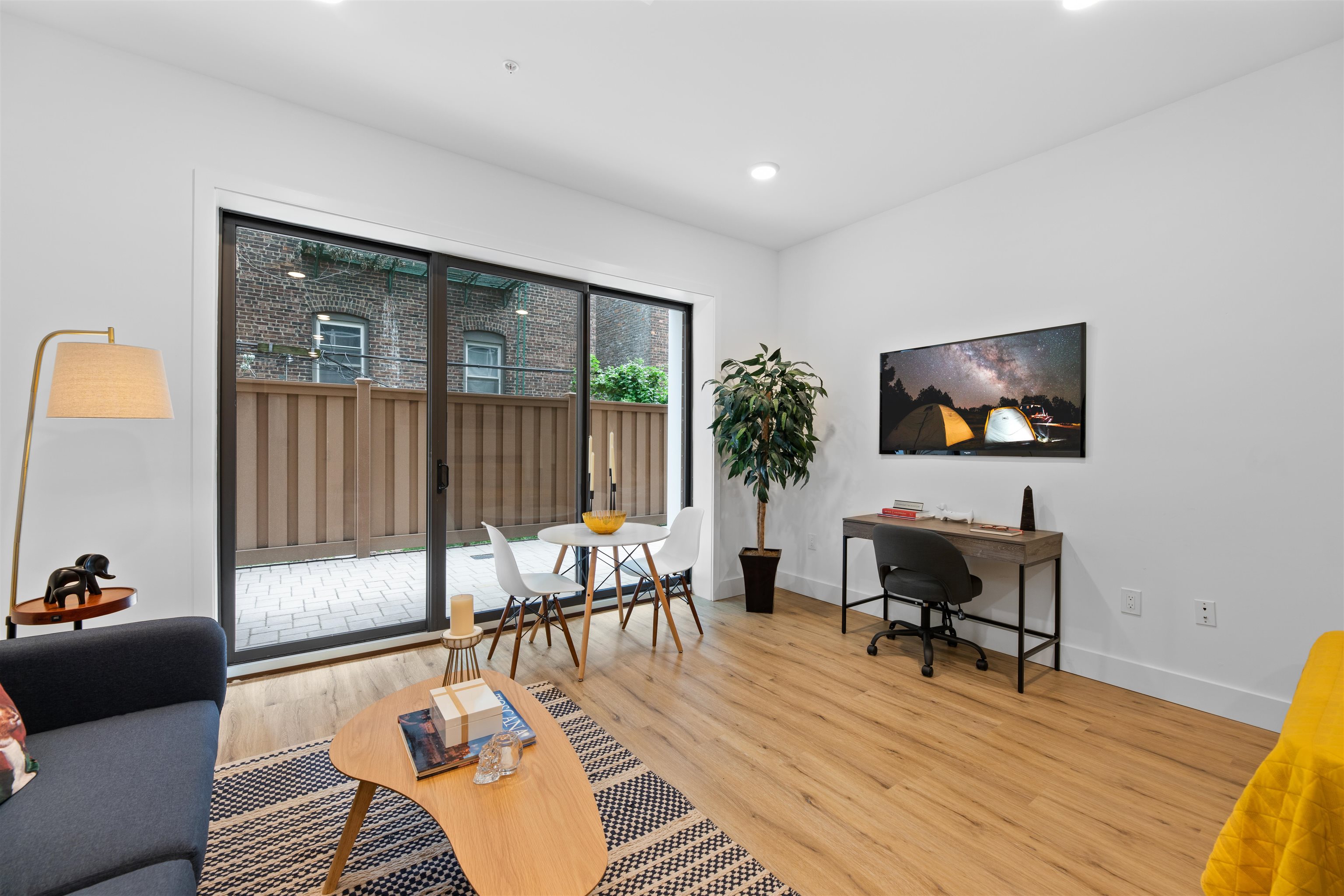 a living room with furniture a rug and a floor to ceiling window