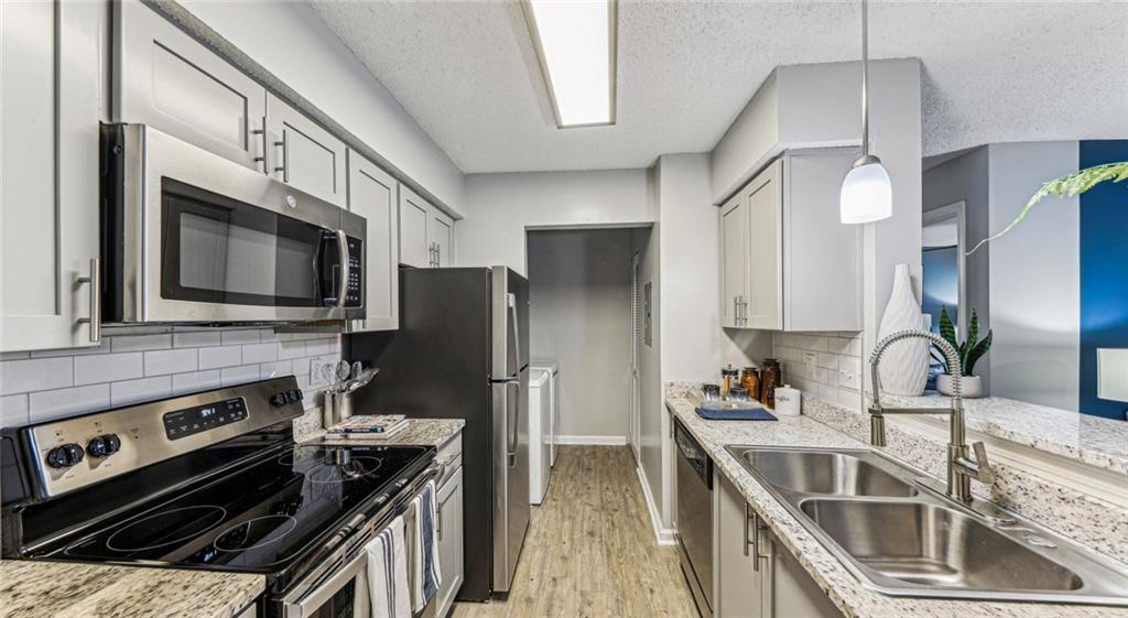 a kitchen with stainless steel appliances a stove a sink and a microwave