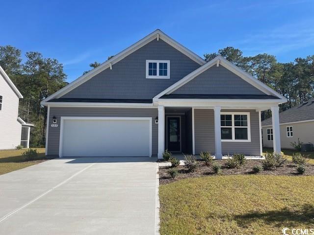 View of front of house with a garage and a front y