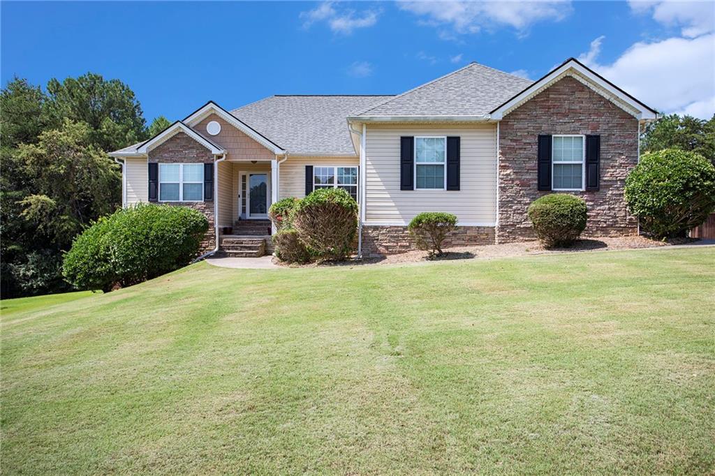 a front view of a house with yard and green space