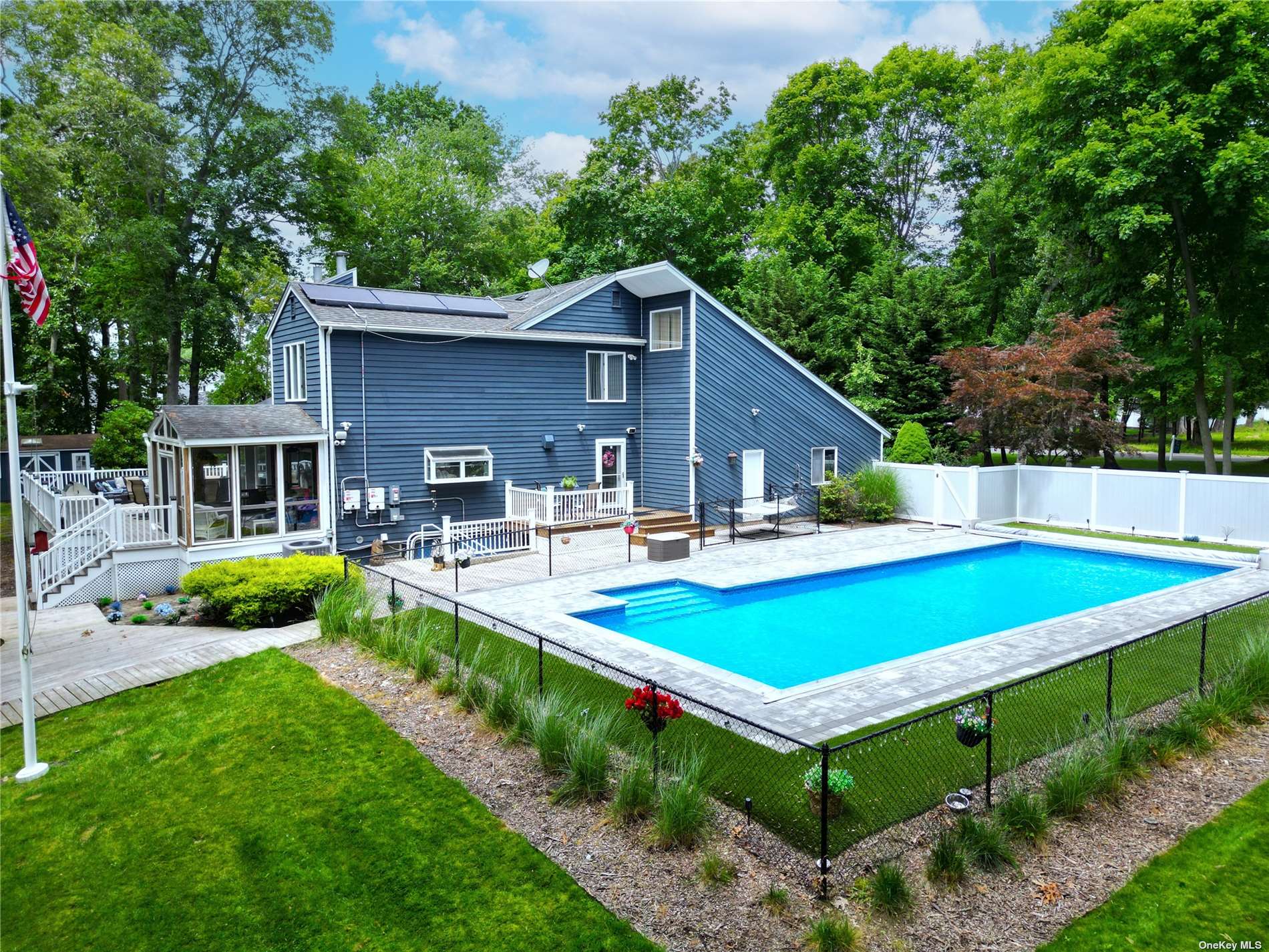 a view of a backyard with swimming pool and chairs