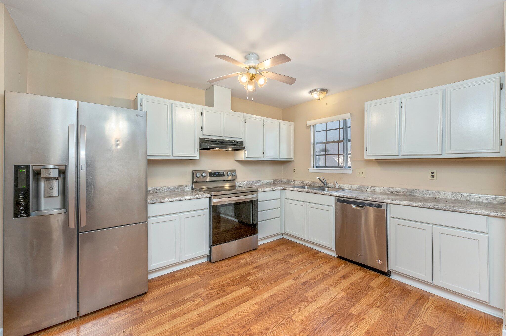 a kitchen with kitchen island granite countertop a sink cabinets stainless steel appliances and a center island