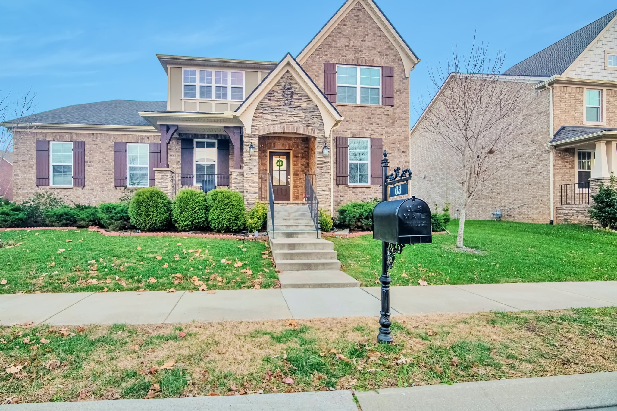 a front view of a house with a yard and plants