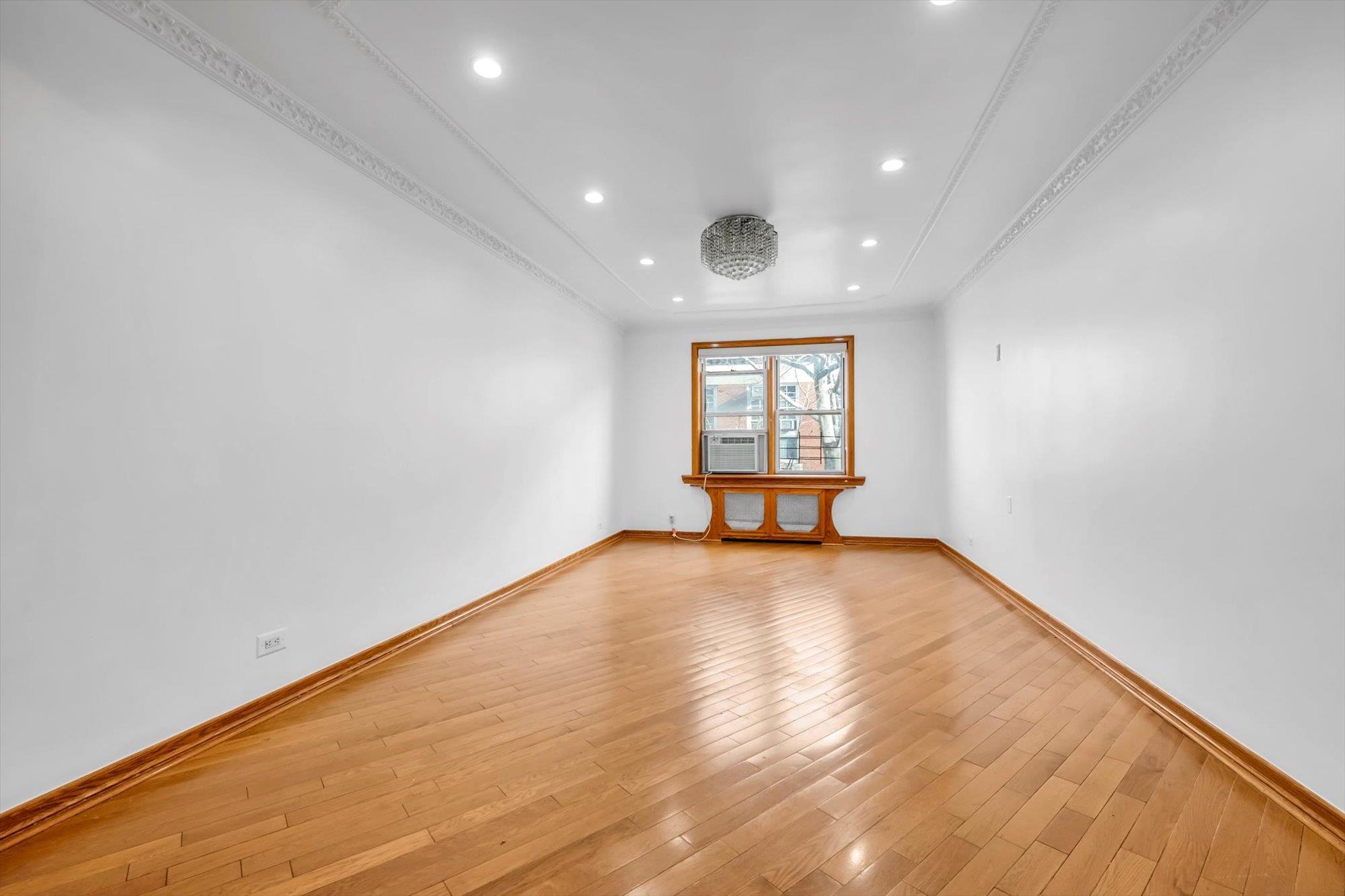 Spare room with light hardwood / wood-style floors, cooling unit, and crown molding