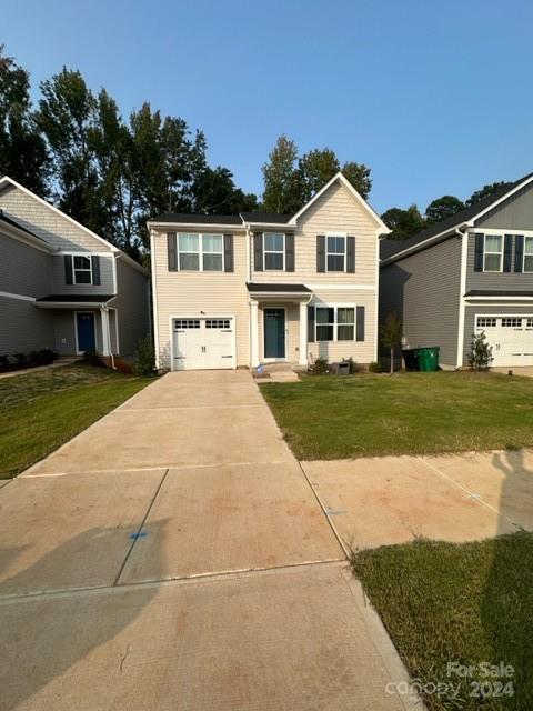 a front view of a house with a yard and trees