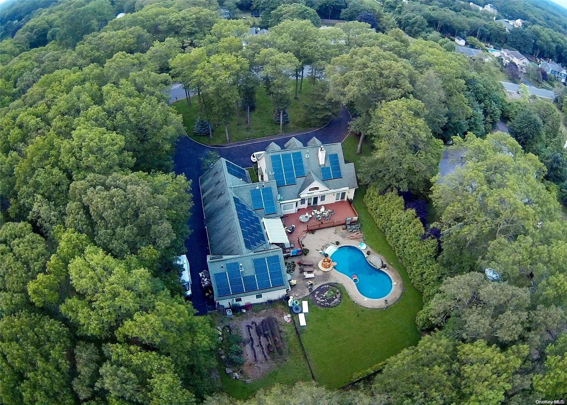 an aerial view of a house with swimming pool outdoor seating and yard