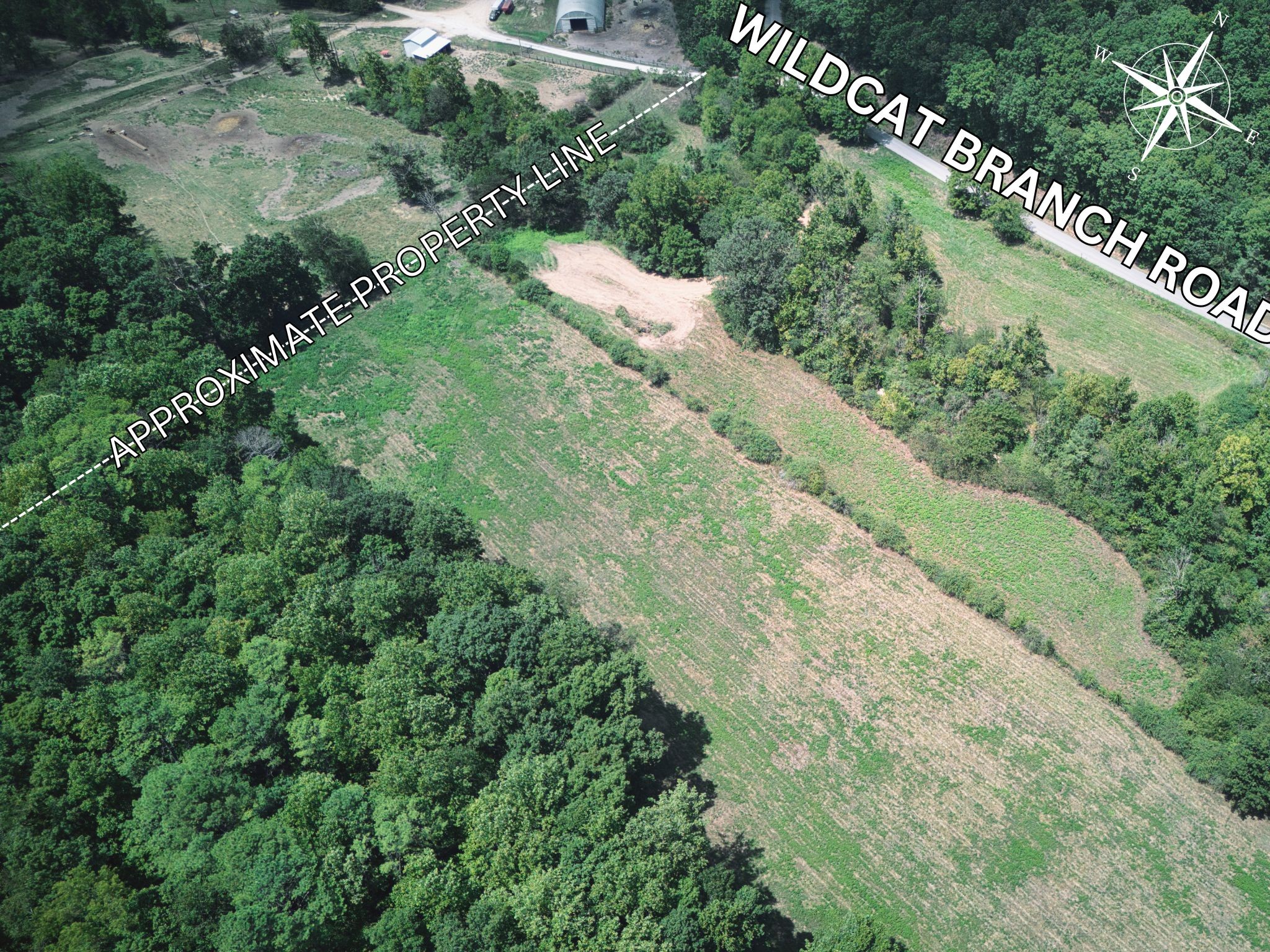 an aerial view of residential house with outdoor space and trees all around