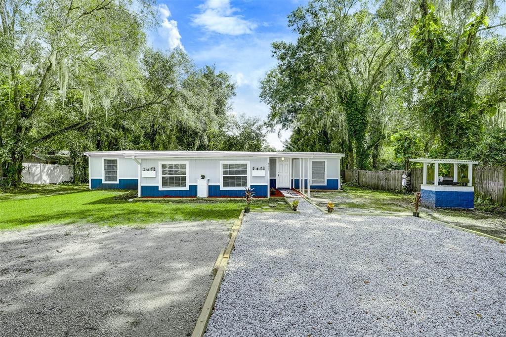 a view of a house with backyard and sitting area