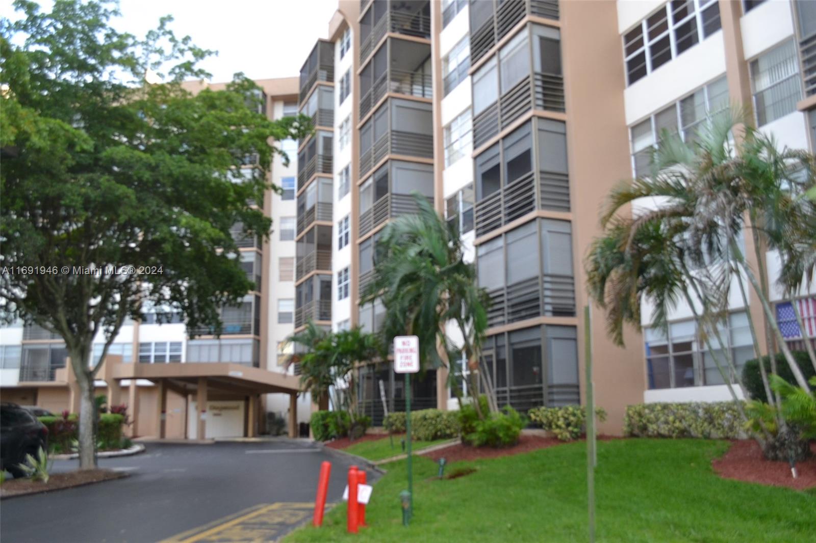 a front view of a multi story building with yard