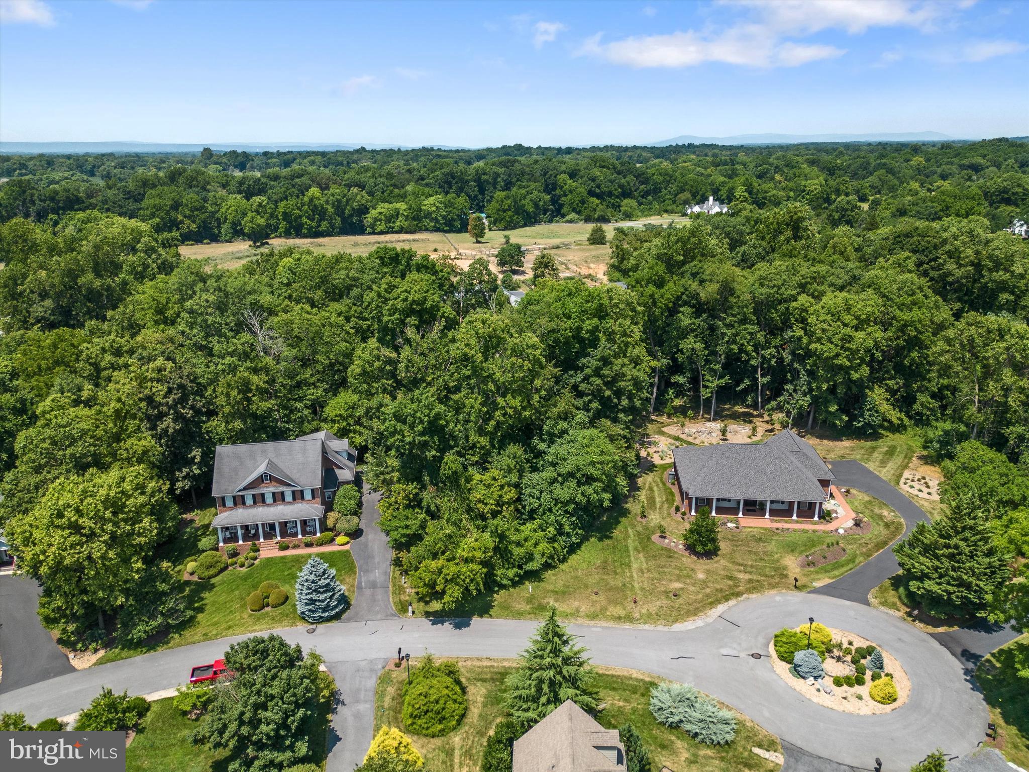 an aerial view of a house with a garden and lake view