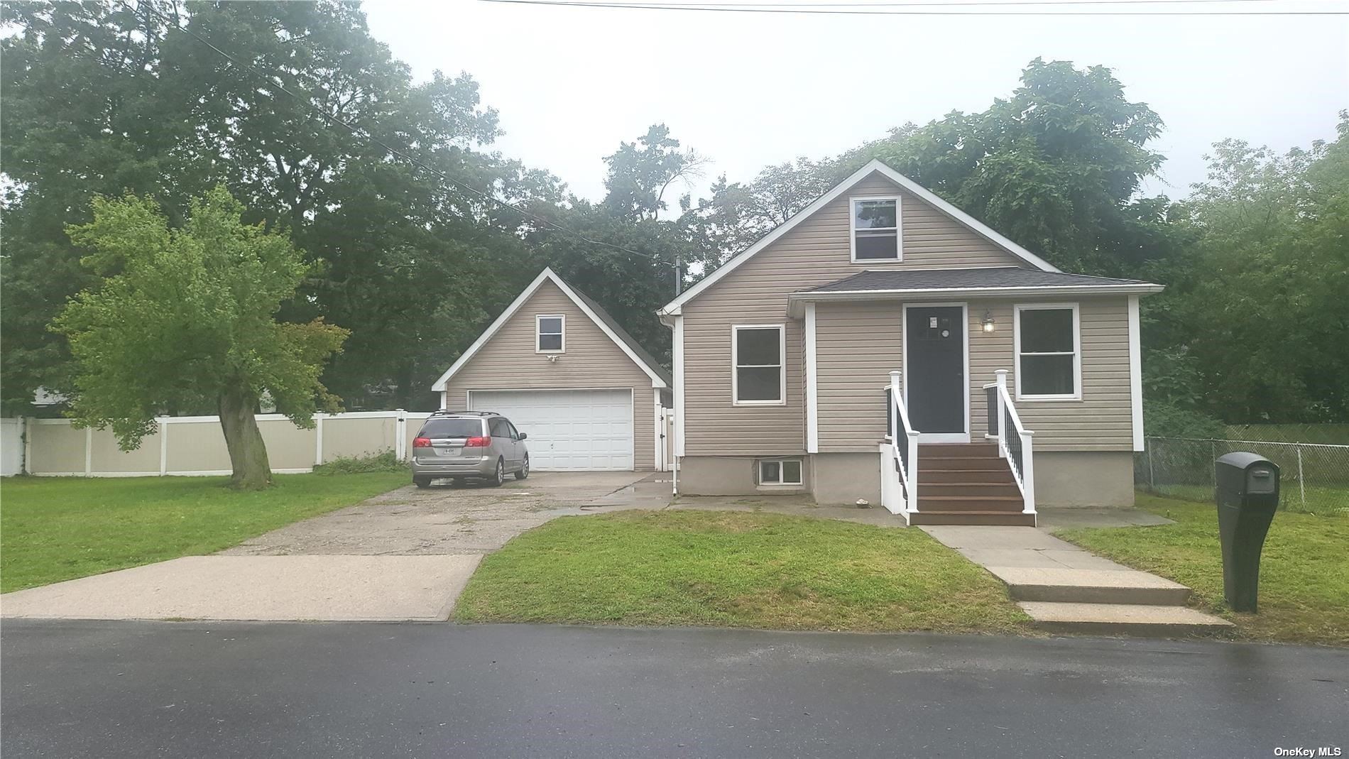 a front view of a house with a yard and trees