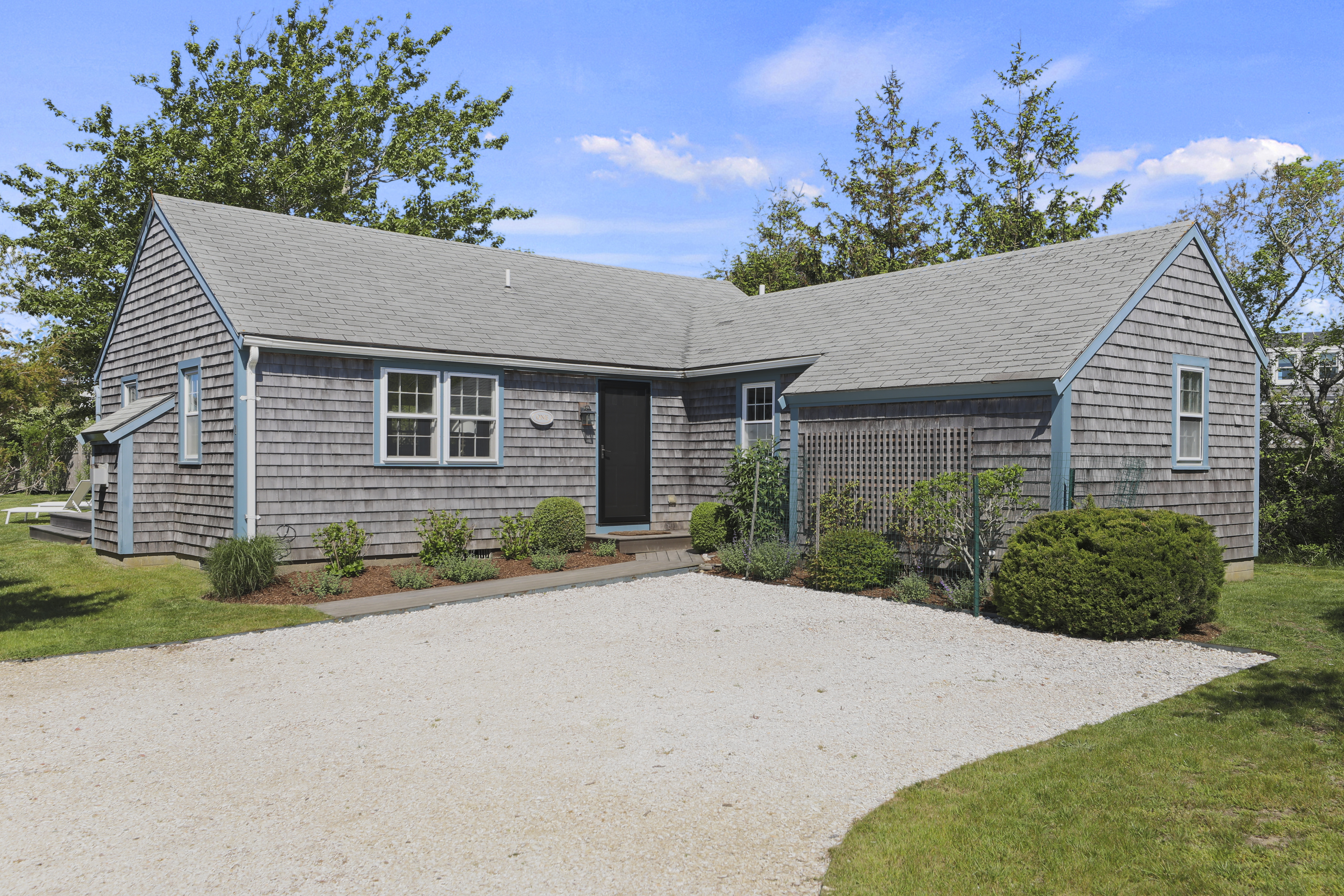 a front view of a house with a yard and potted plants