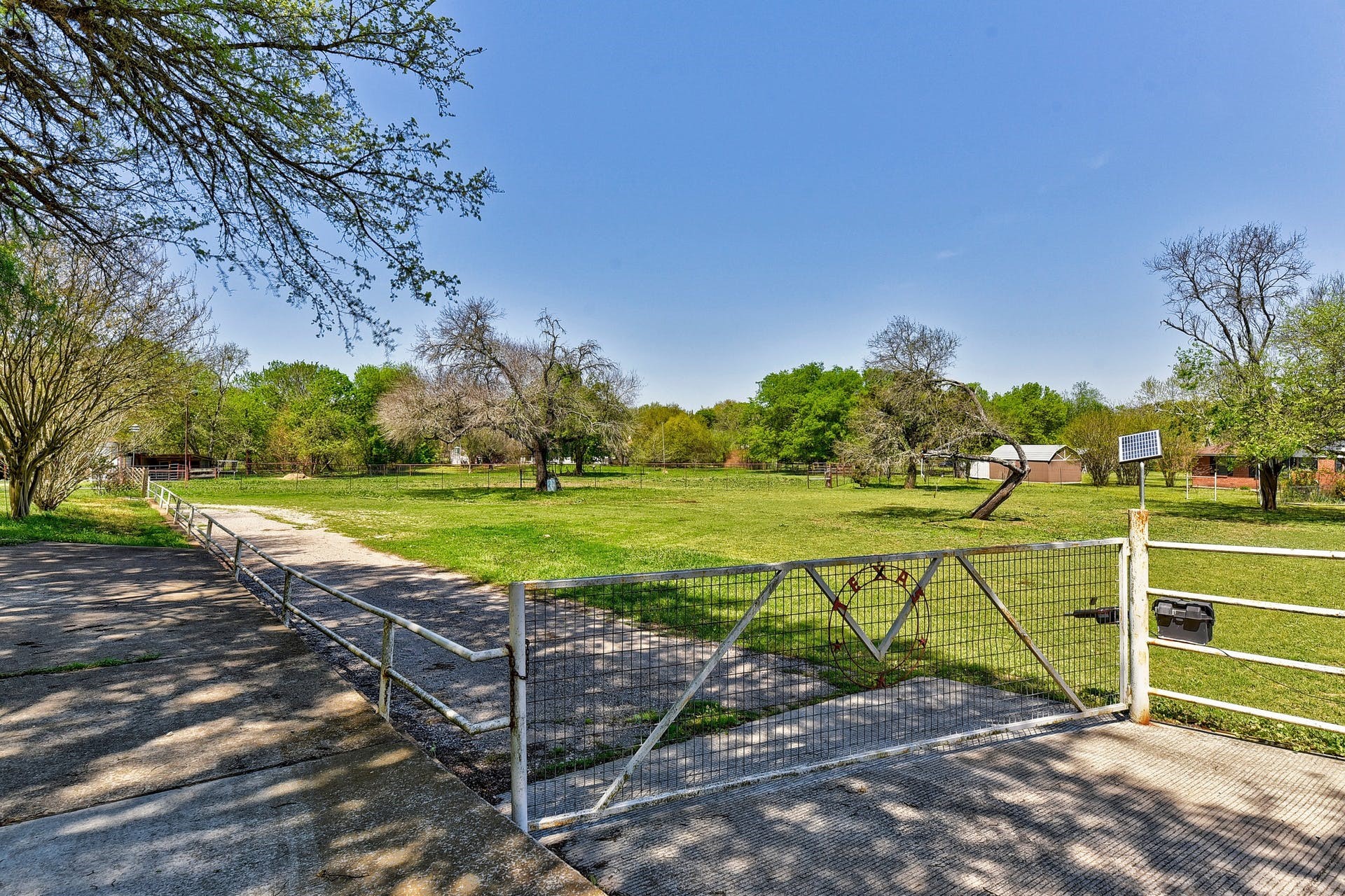 a view of a tennis ground with large trees