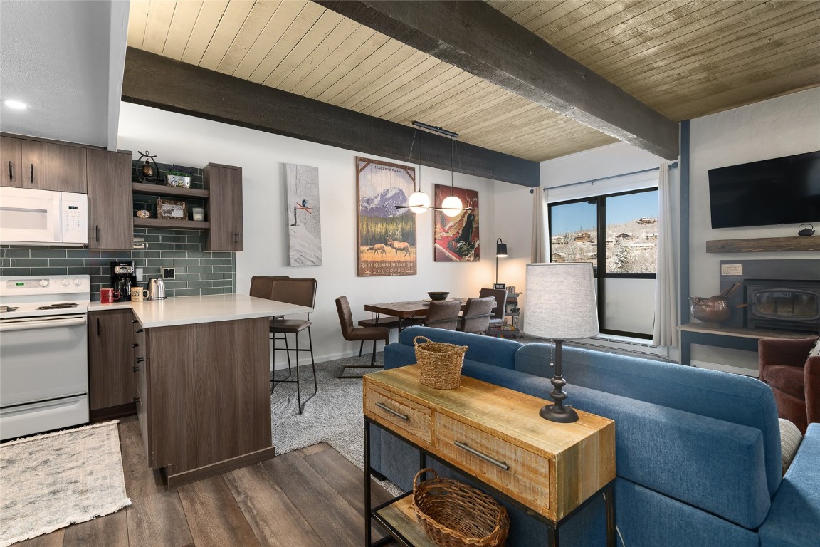 a living room with furniture a flat screen tv and kitchen view