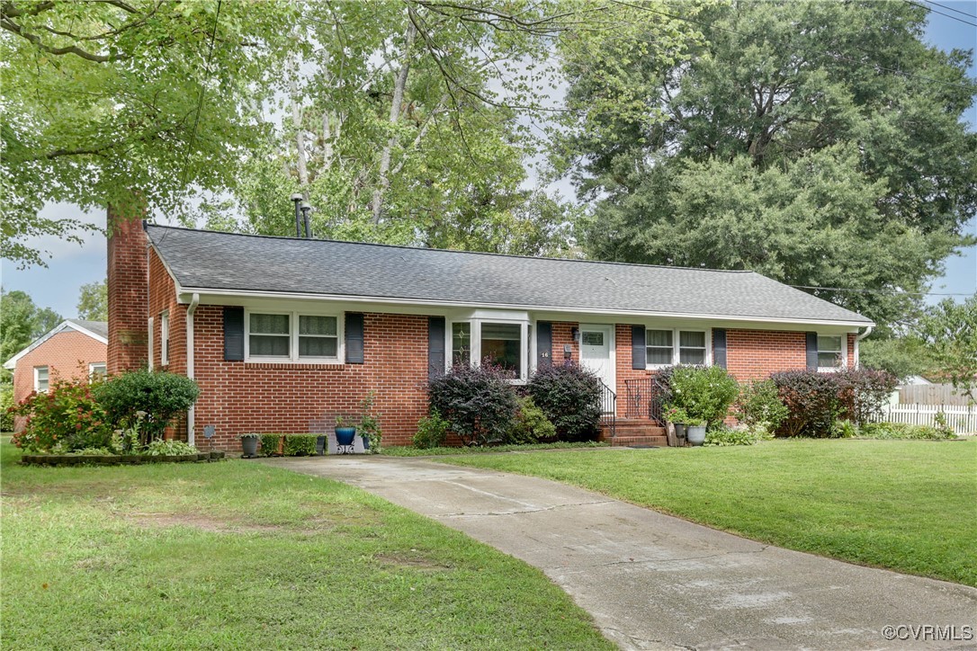 a front view of a house with a yard and potted plants