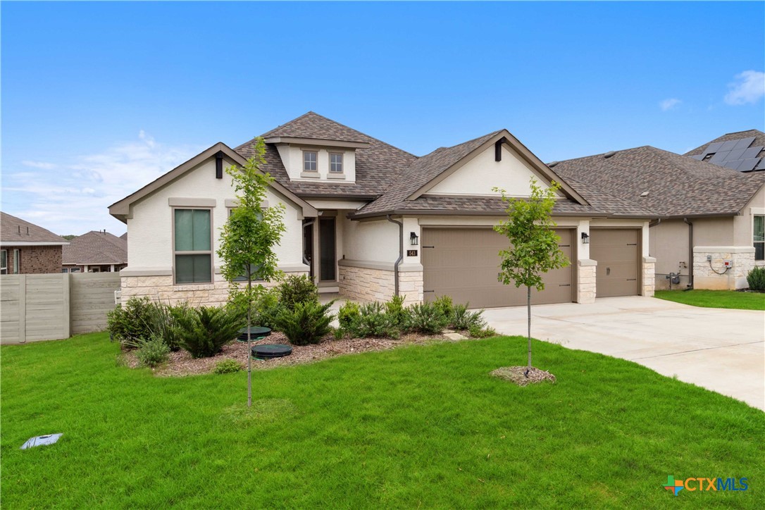 a front view of a house with a garden and plants