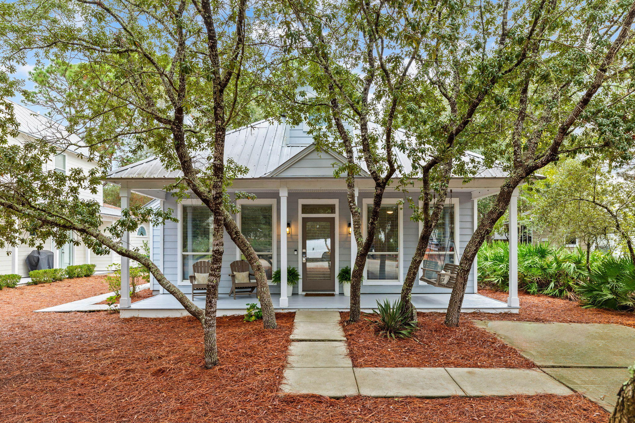 a front view of a house with a tree