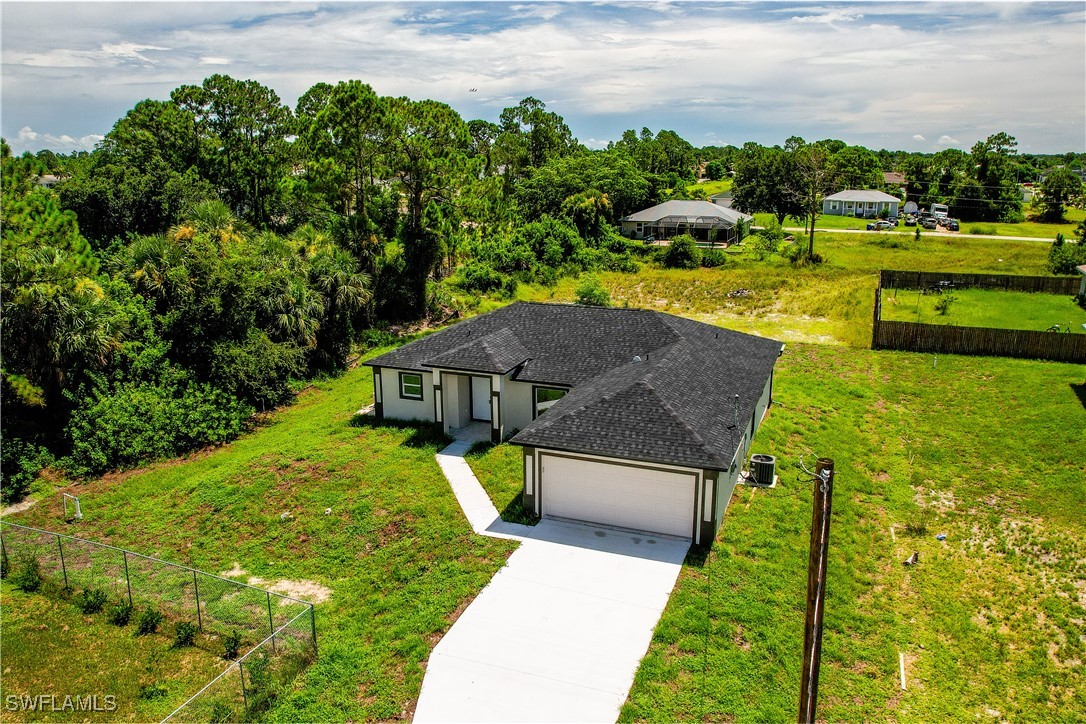 a view of a house with big yard and large trees