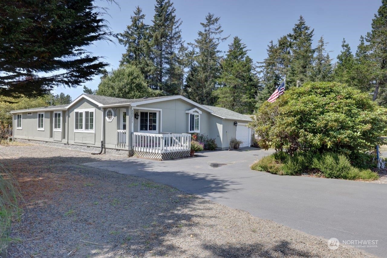 a front view of a house with a garden and trees