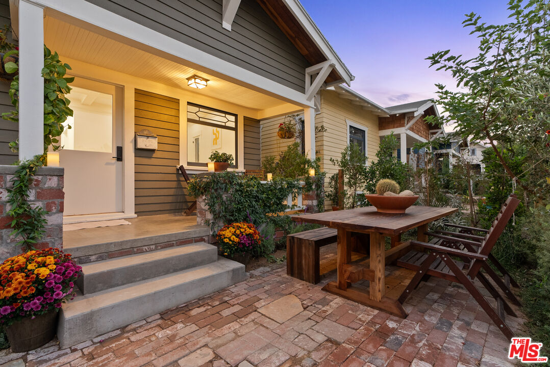 a view of backyard with outdoor seating and plants