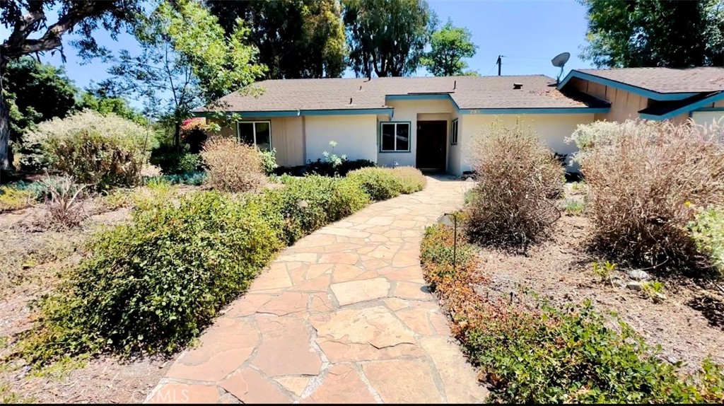 a view of a house with a yard and pathway