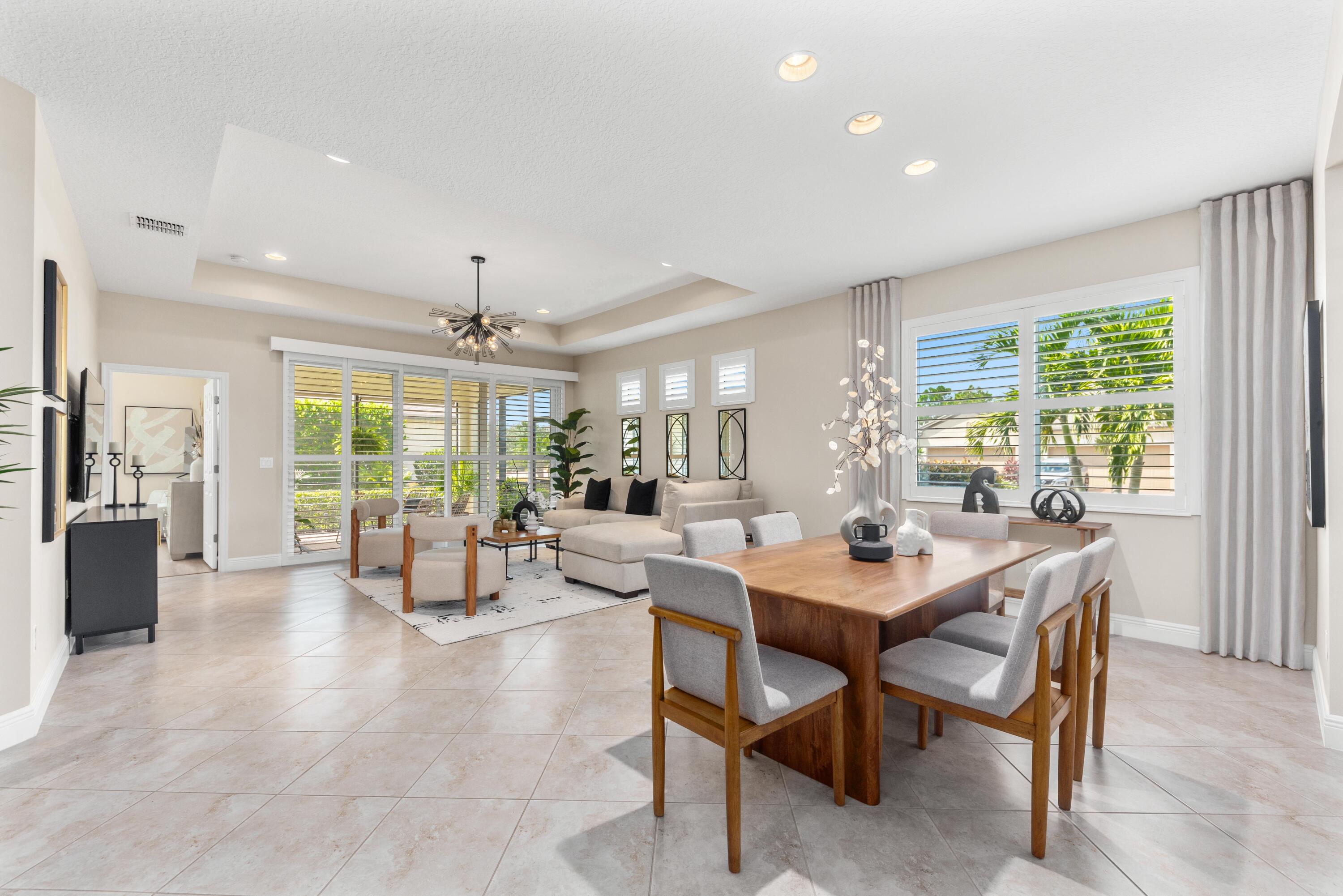 a dining room with furniture a chandelier and wooden floor