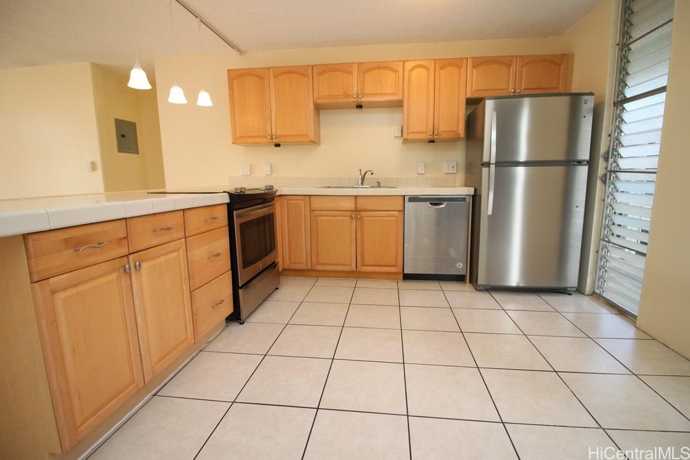 a kitchen with a stove a sink dishwasher a refrigerator and cabinets