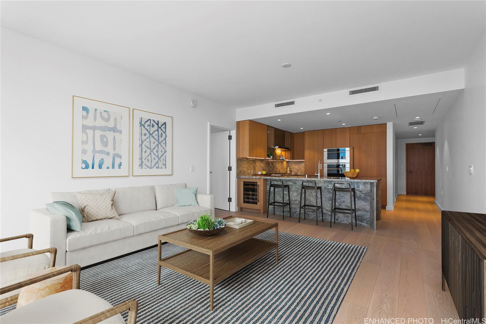 a living room with furniture kitchen view and a window