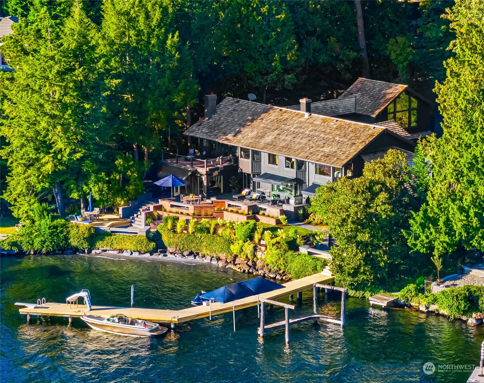 an aerial view of a house with swimming pool a yard and lake view