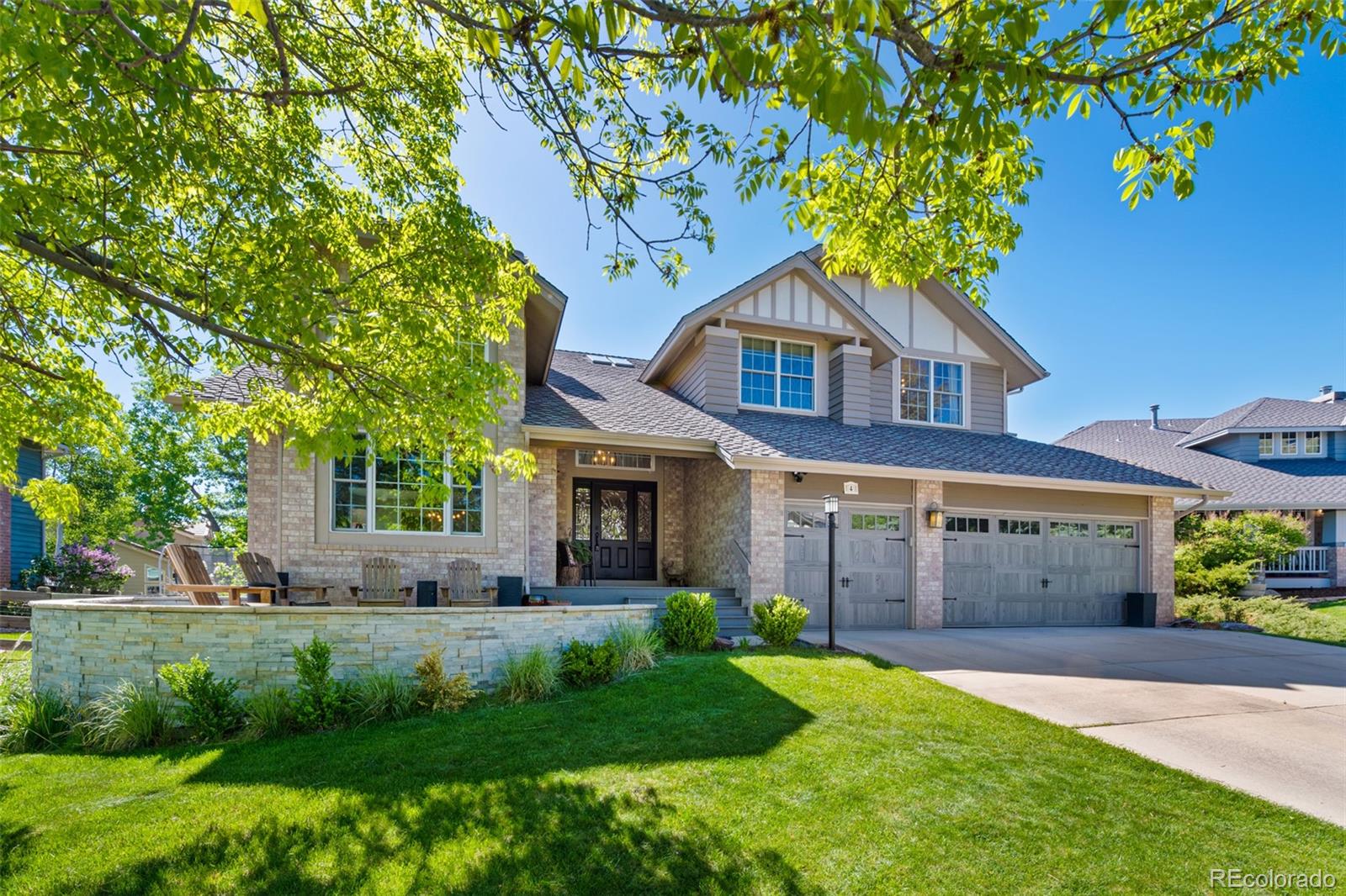 a front view of a house with a garden and trees