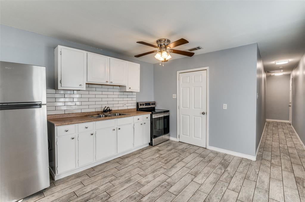 a kitchen with granite countertop a sink stainless steel appliances and cabinets