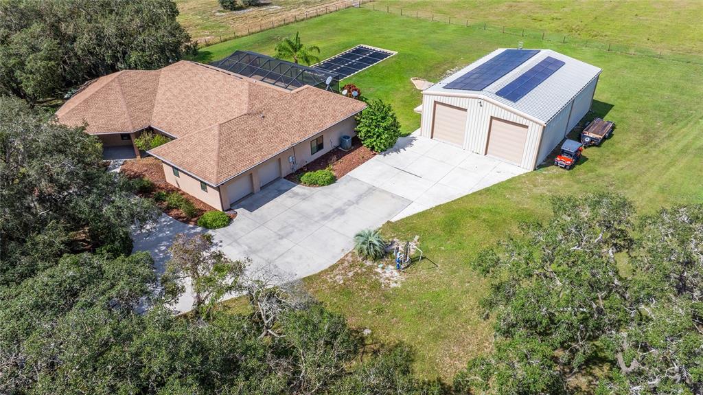 an aerial view of a house with yard and mountain view in back