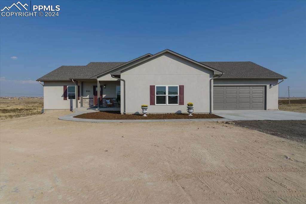 a view of the house with a yard and garage