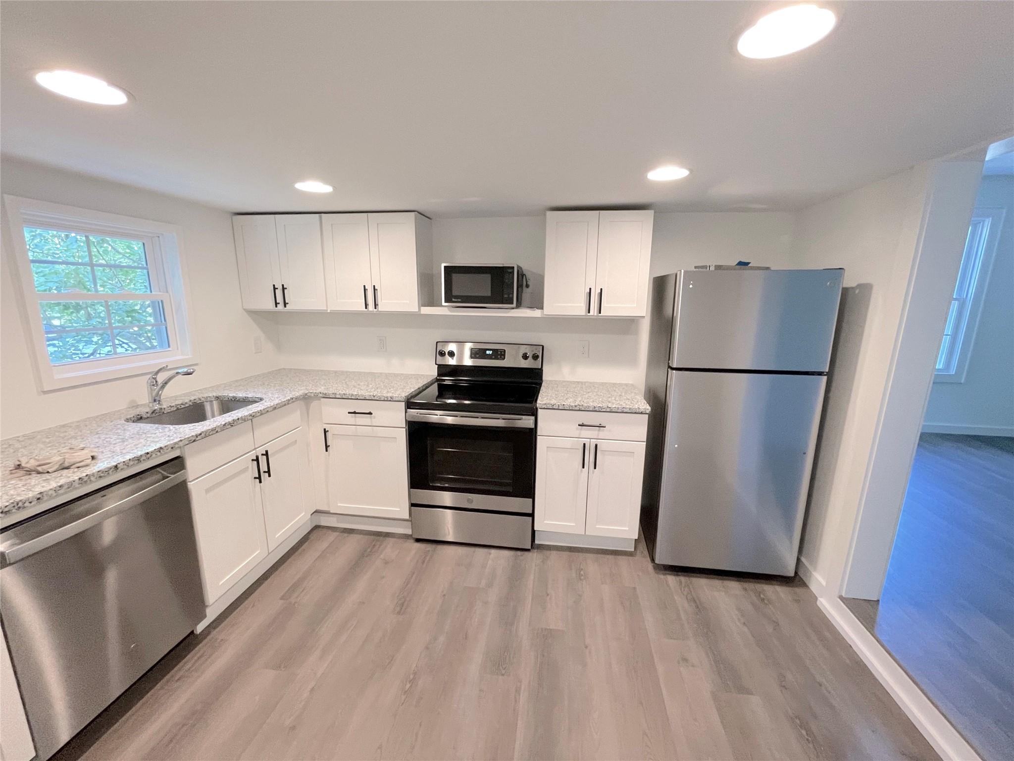 Kitchen featuring white cabinets, appliances with stainless steel finishes, and sink