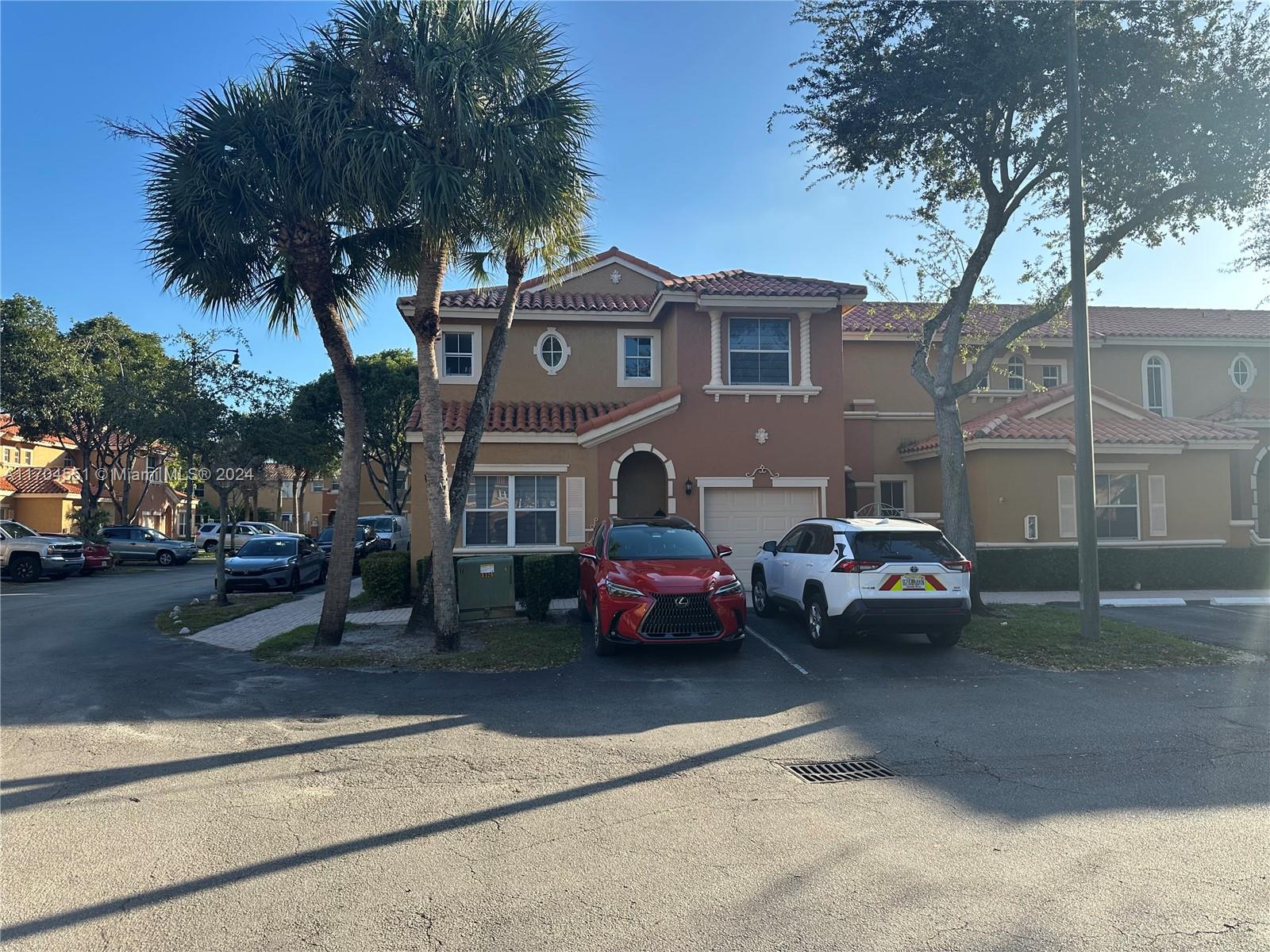 a front view of a house with cars parked