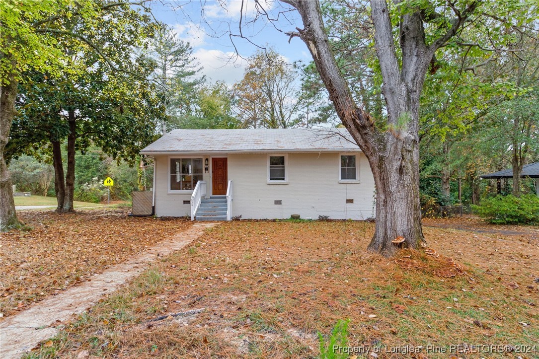 a view of a house with a tree in front of it