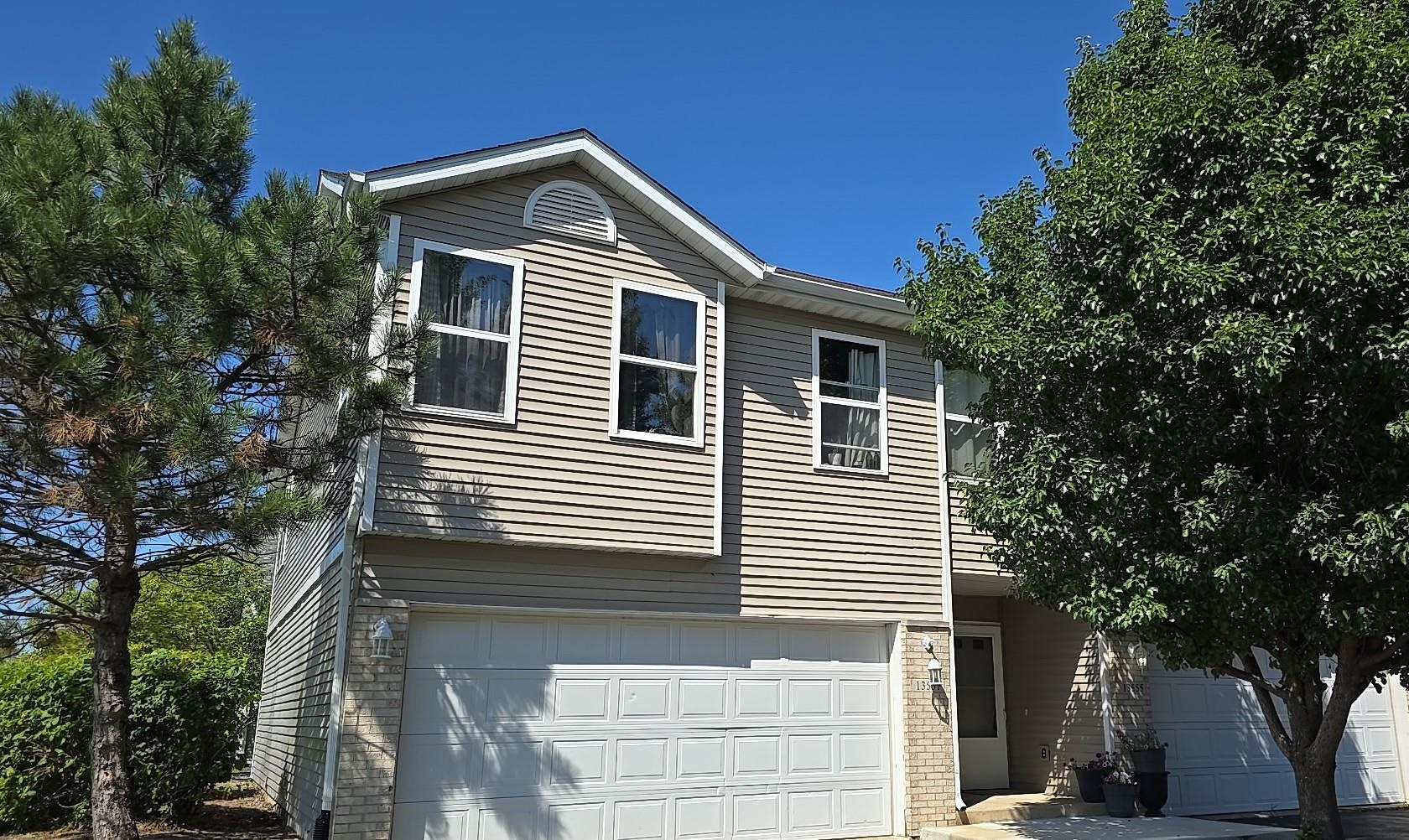 a front view of a house with a tree