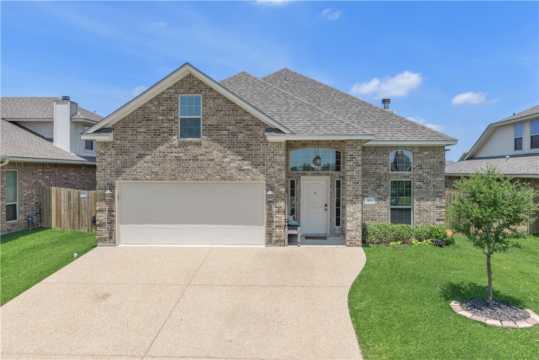 View of front of home with a garage and a front la