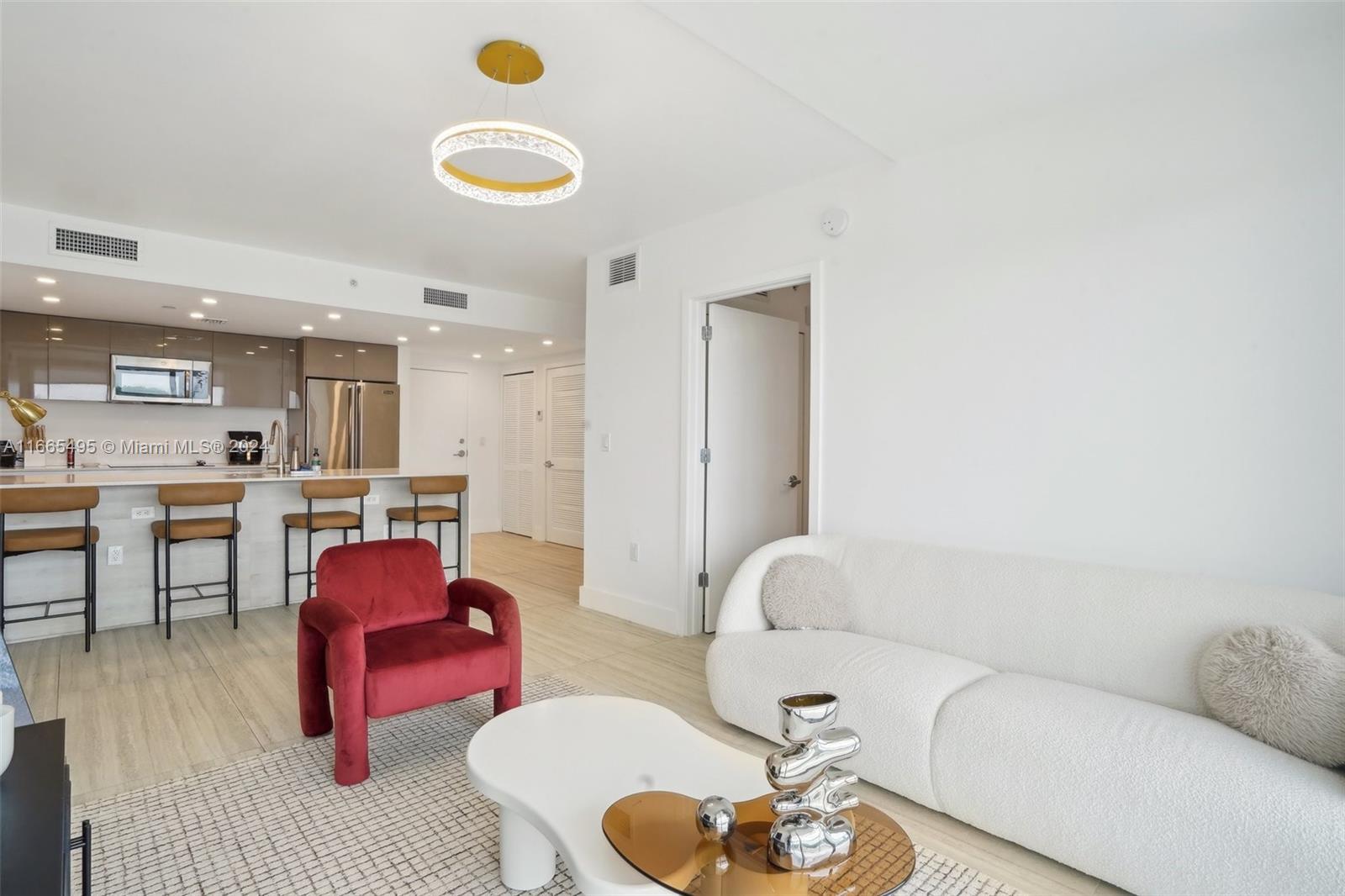 a living room with furniture and kitchen view