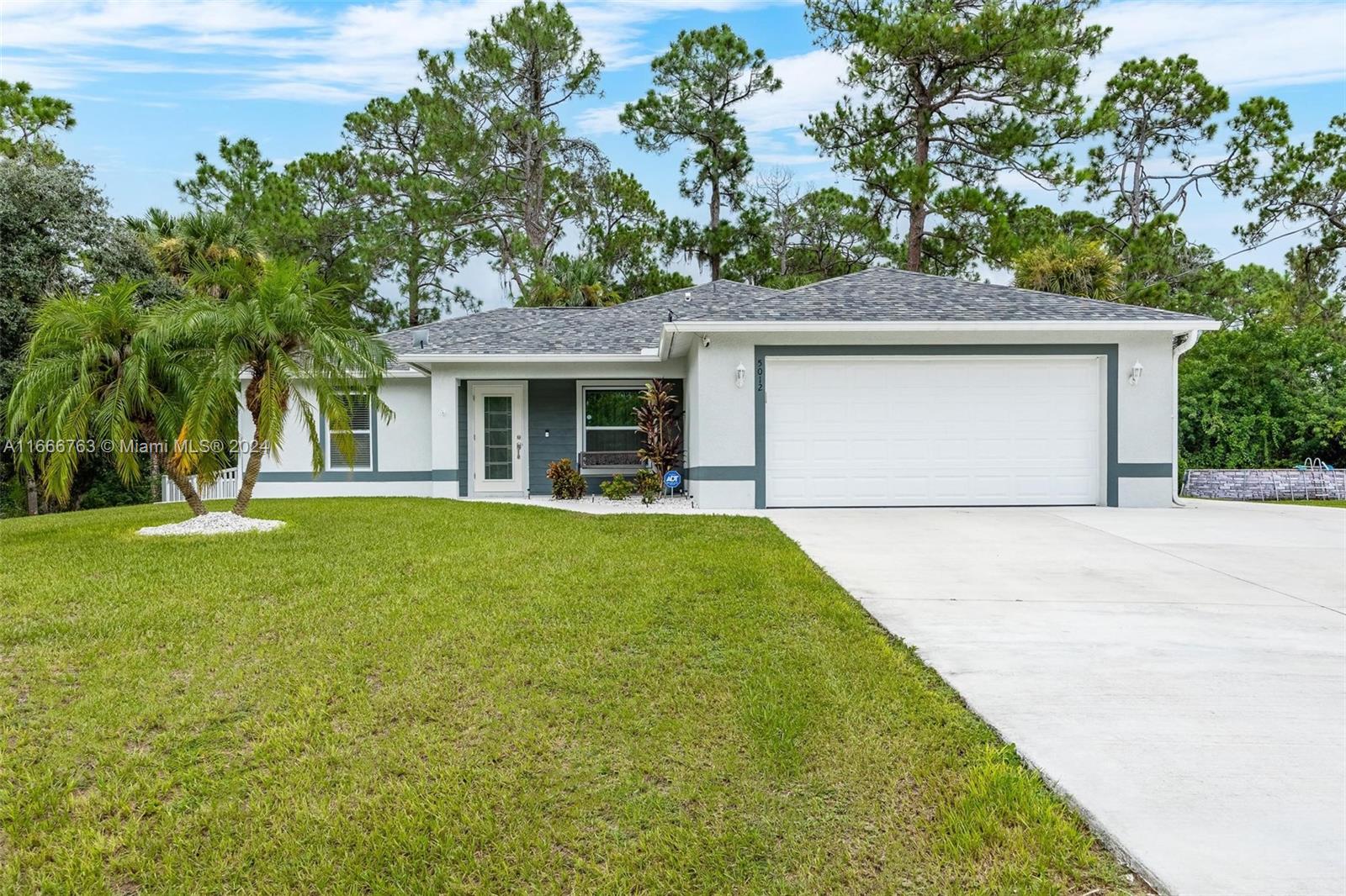 a front view of house with yard and trees