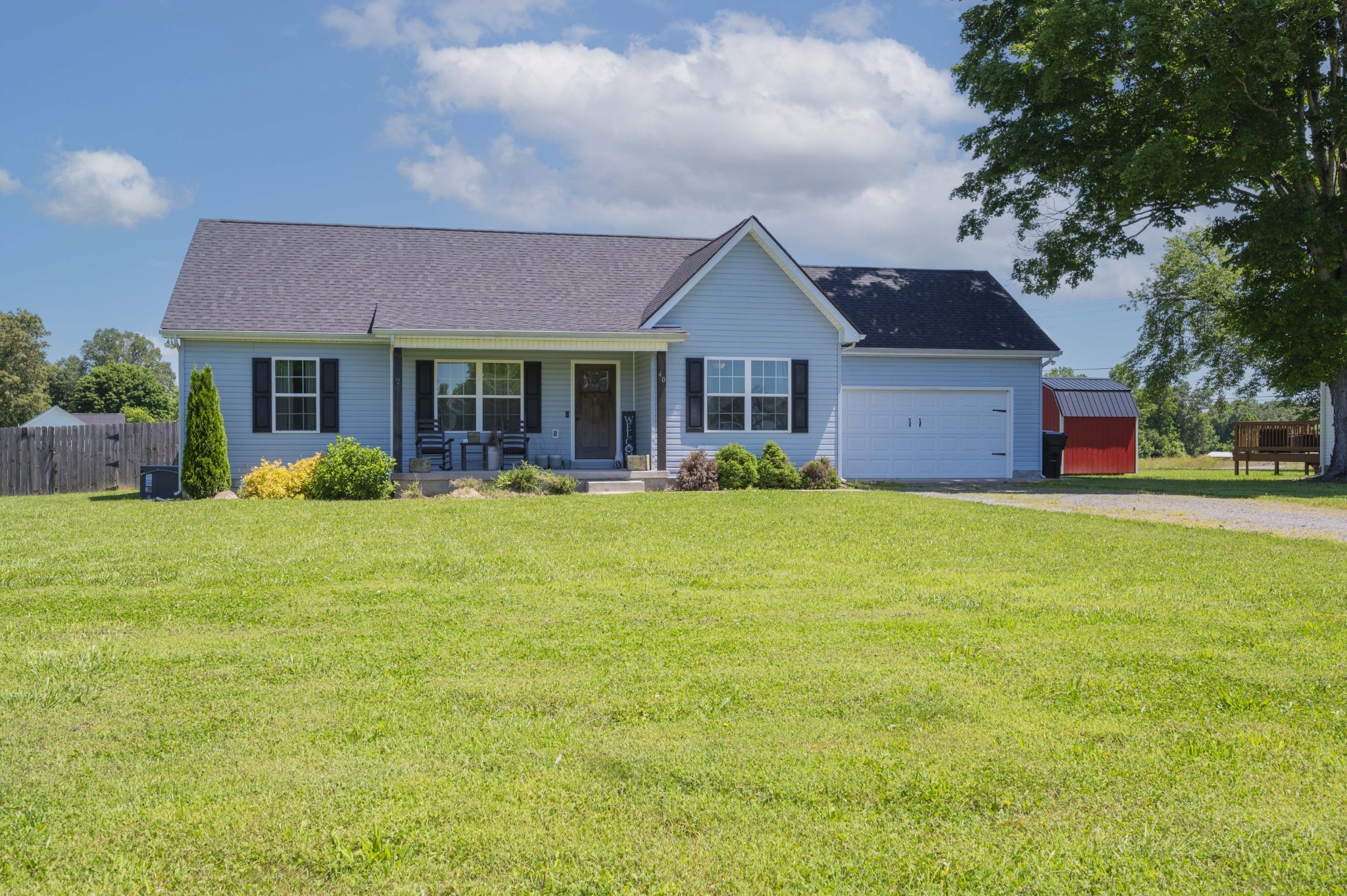 a view of a house with a big yard and potted plants